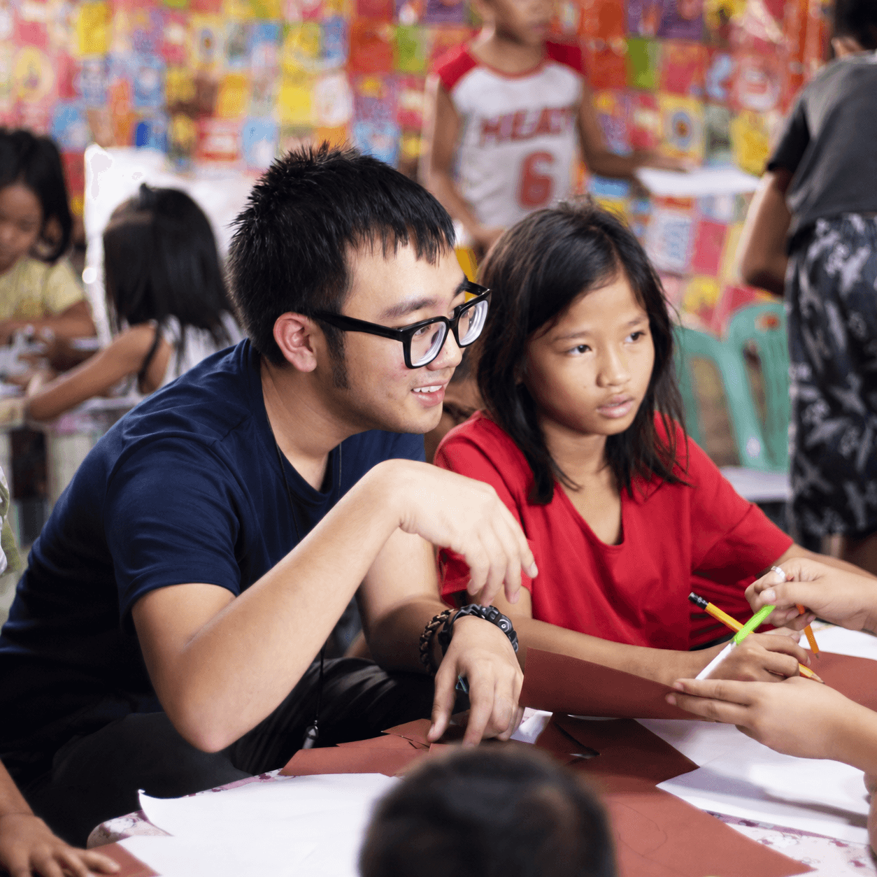 A Great Heart volunteer helping a child during a creative activity
