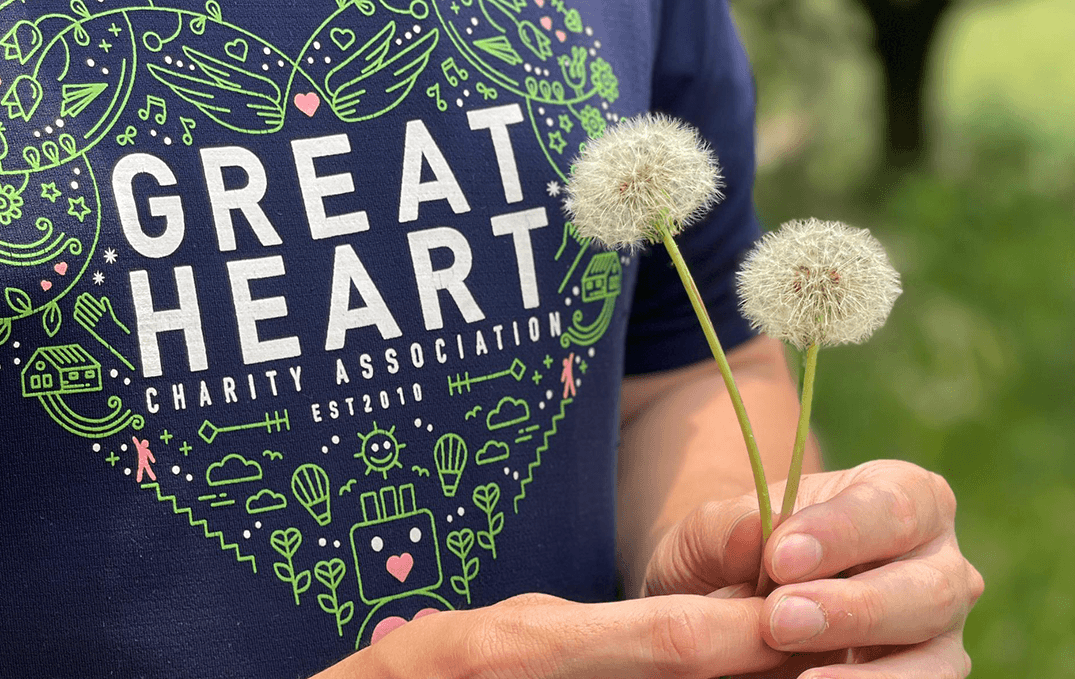 A Great Heart volunteer holding dandelions