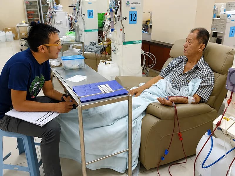 A volunteer speaking with a dialysis patient