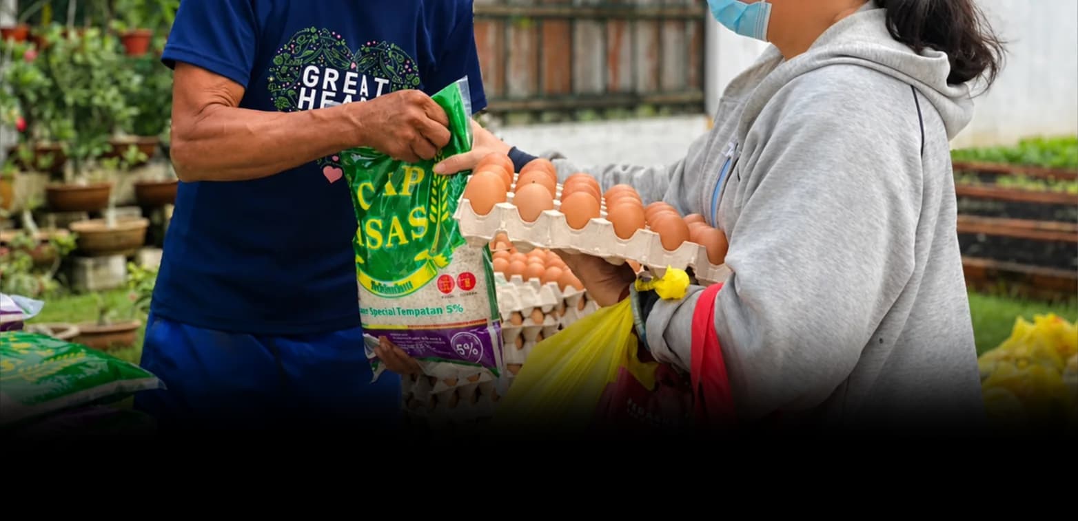 Great Heart volunteers distributing rice and eggs through the Hand-in-Hand Charity Program