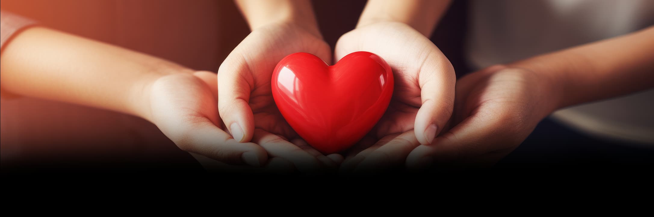 Hands holding a red heart together
