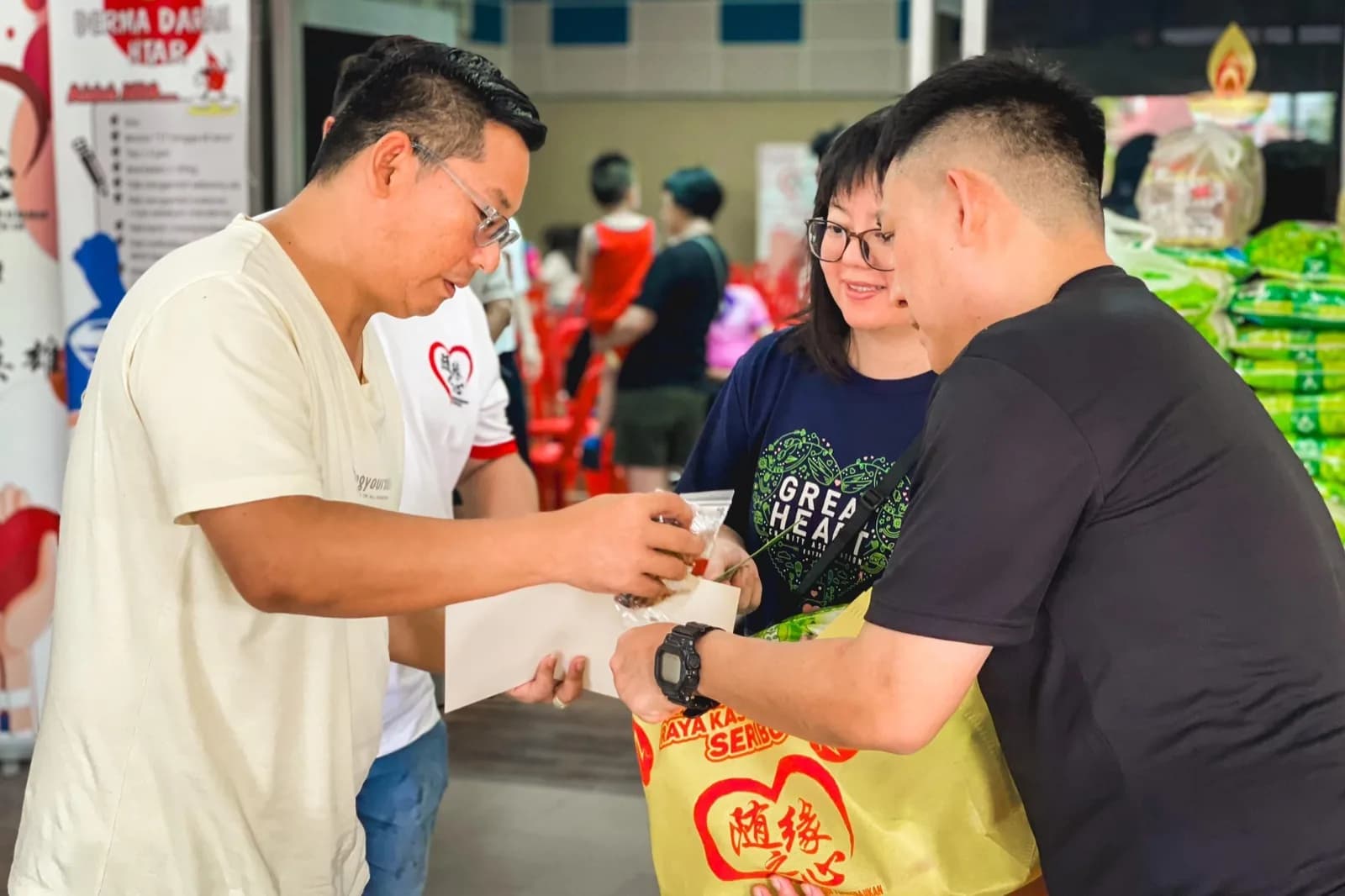 Volunteers presenting essential supplies to a beneficiary