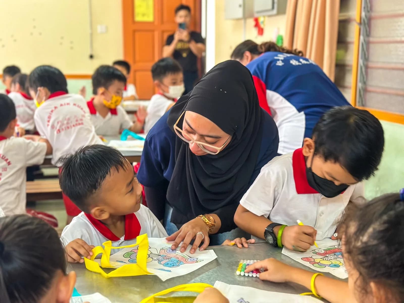 A volunteer guiding children through a creative activity