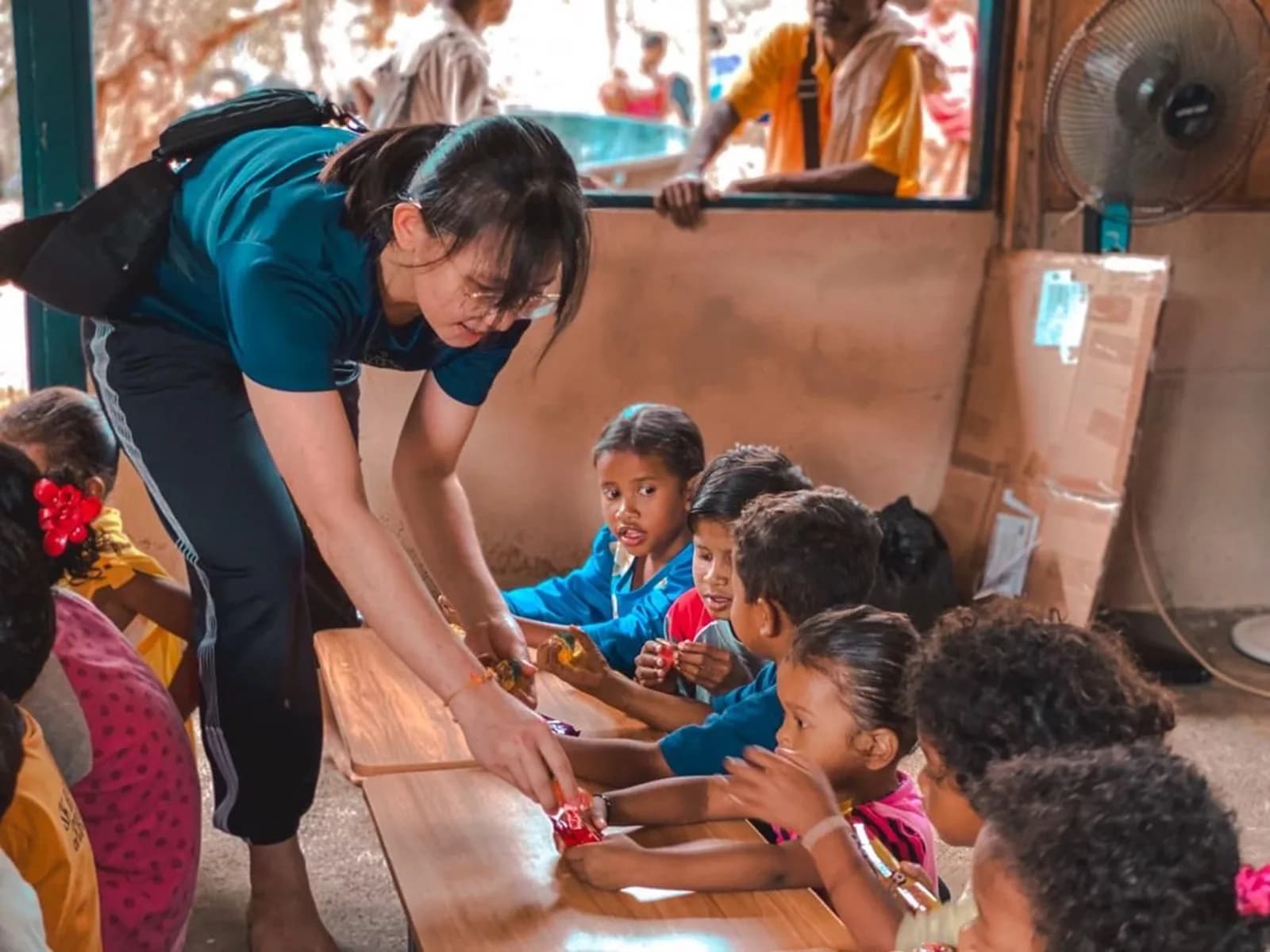 A volunteer supporting children during a community programme