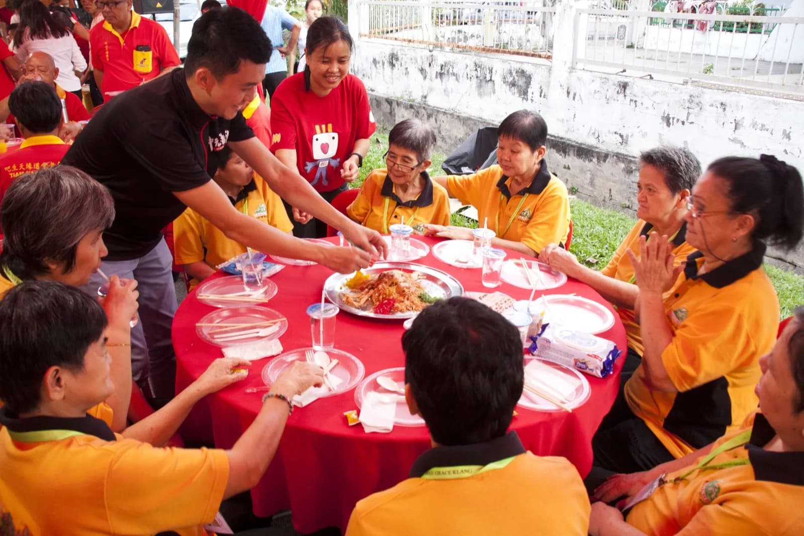 A volunteer serving a festive meal to senior beneficiaries